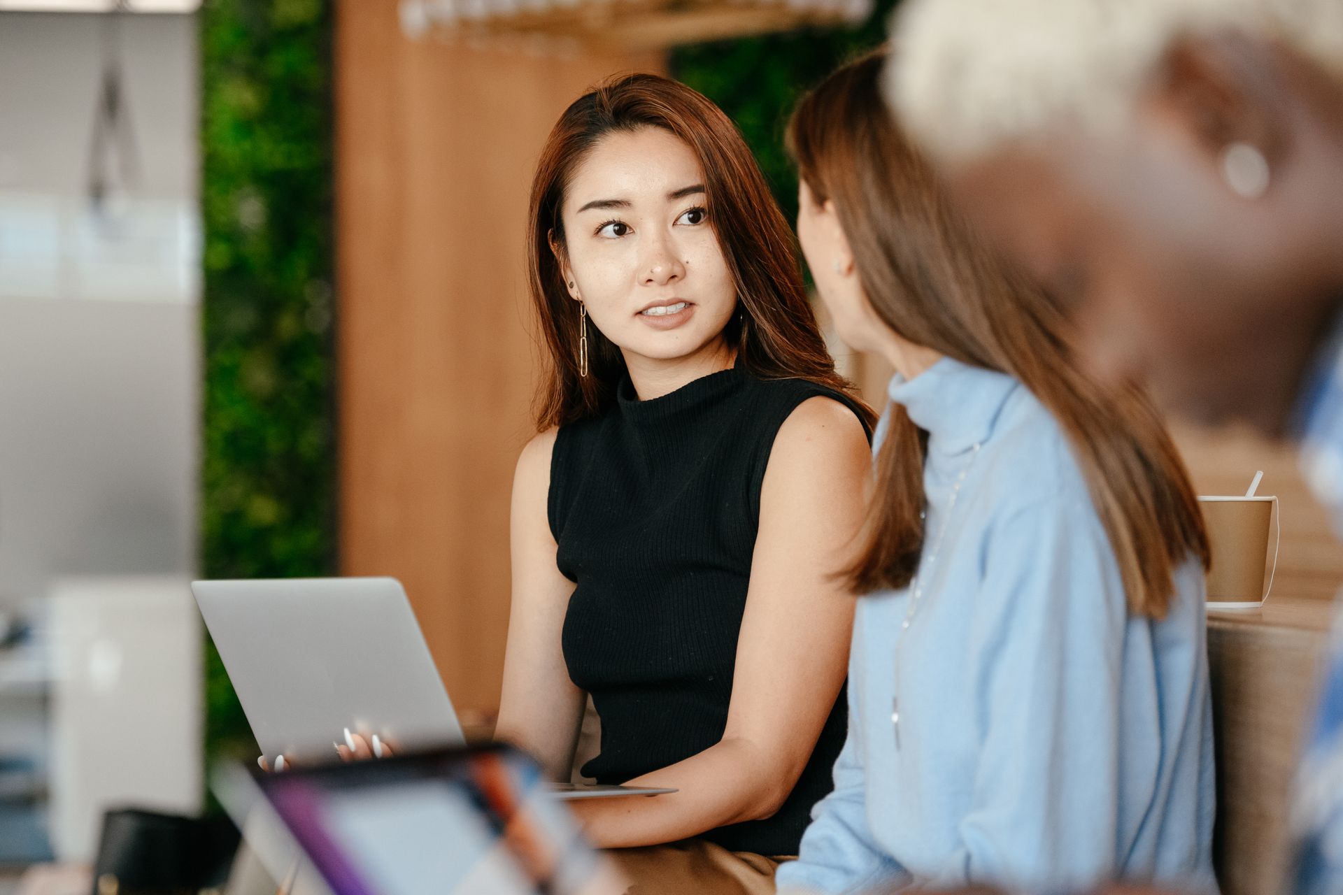 An Asian colleague sharing ideas with a small, culturally diverse workplace group